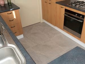 A kitchen with new gray tiles