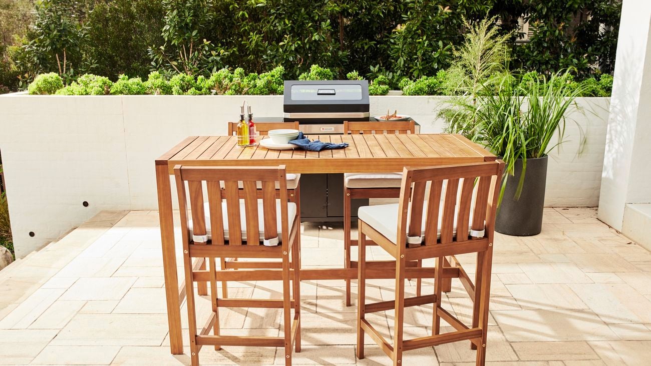 Tall timber bar stools, timber bar table and Matador barbecue on a patio