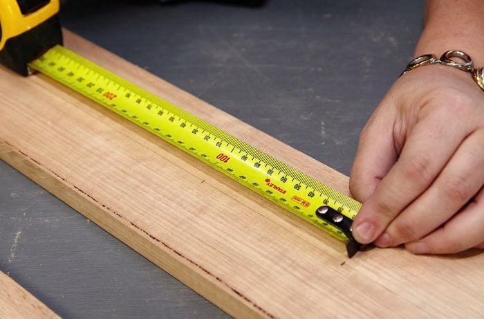 Person marking holes to be drilled for dowels