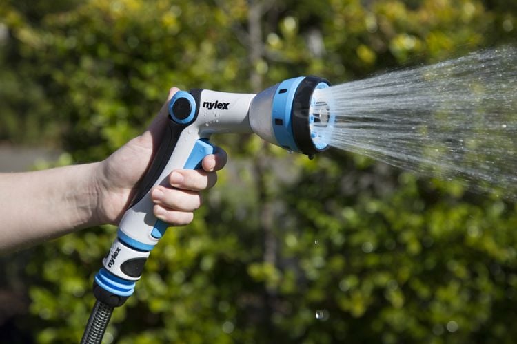 Person using hose with trigger nozzle