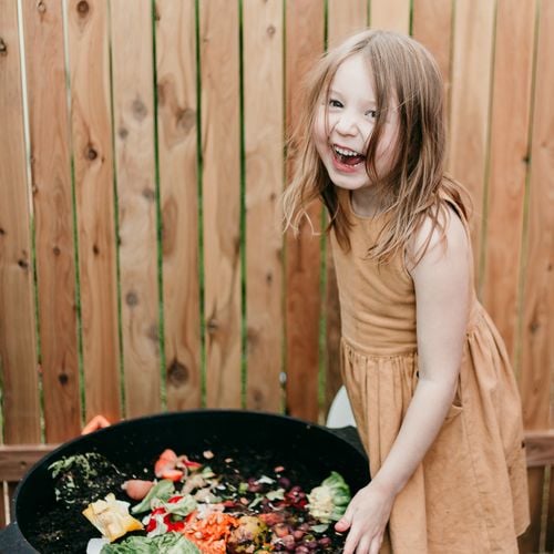 A child looking into a compost bin