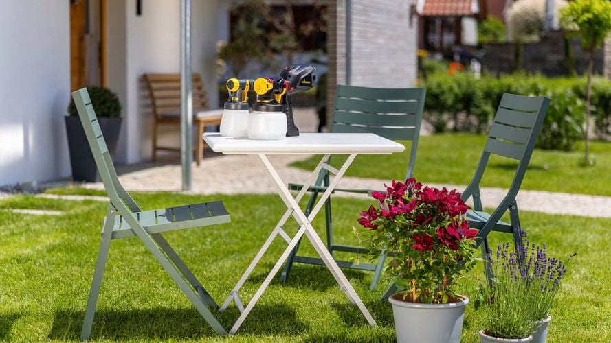 Wagner Flexio W575 with i-Spray and Standard Spray attachment sitting on outdoor furniture set after chairs have been painted in green.