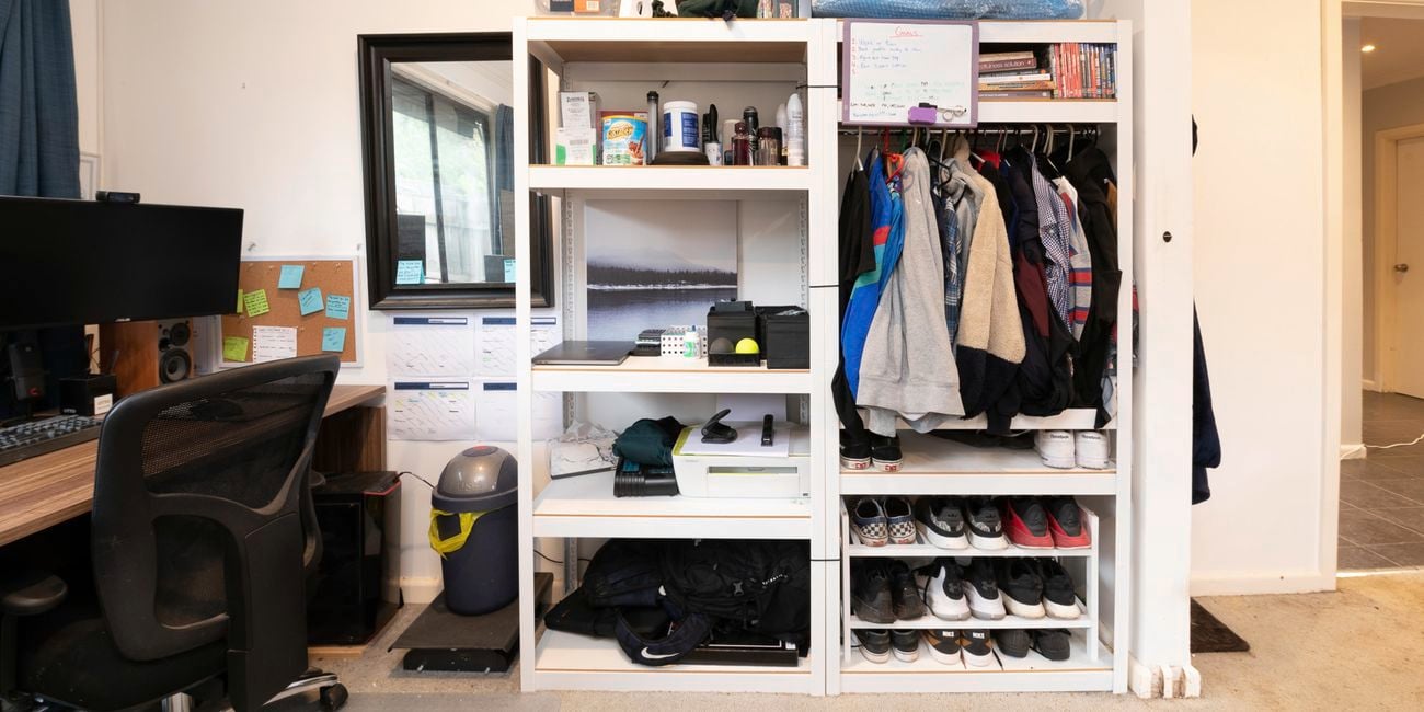 Messy wardrobe and cluttered desk.