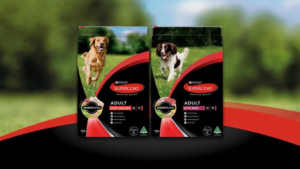 Two bags of Pruina Supercoat dog food featured on a grassy field, highlighting their packaging and nutritional information for potential buyers.