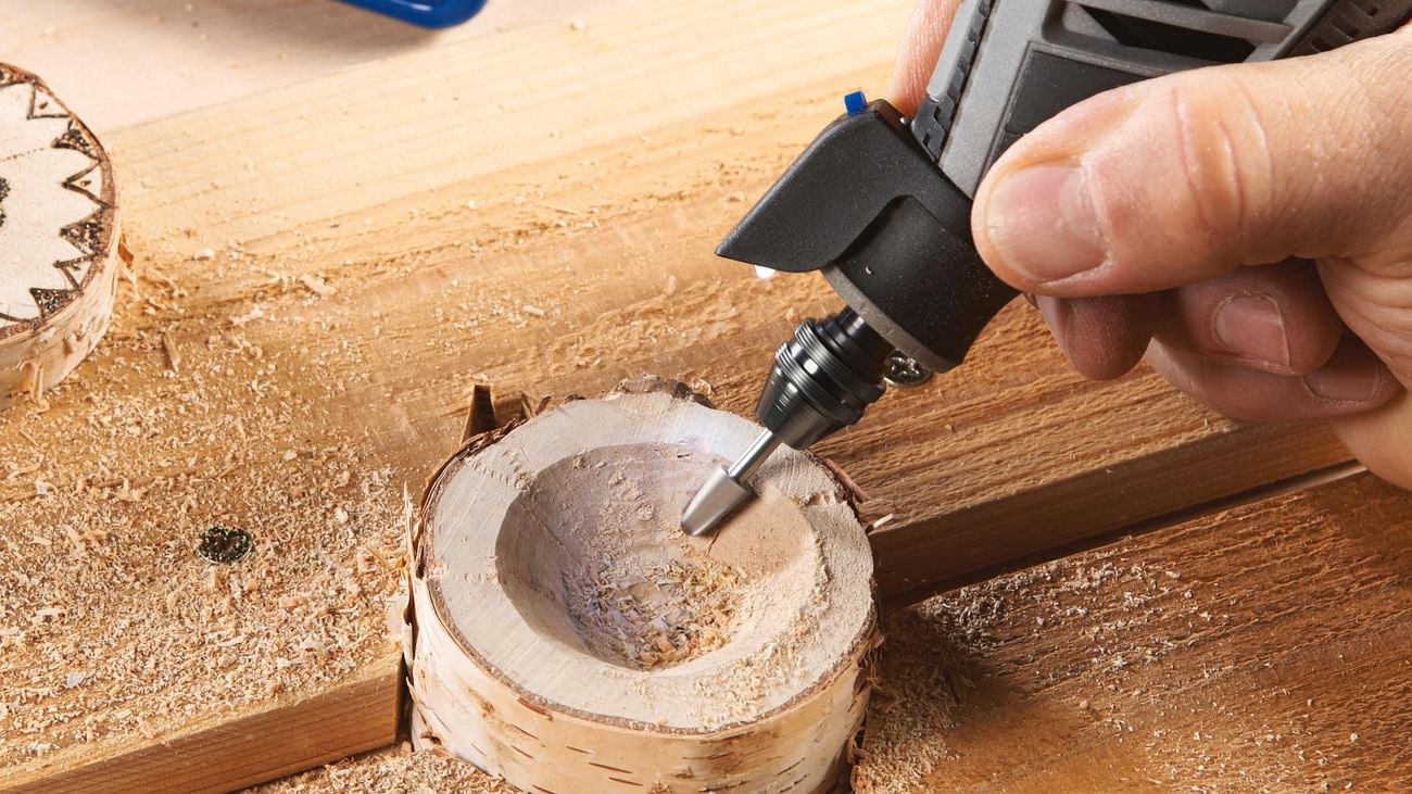 Person carves into timber with a rotary tool
