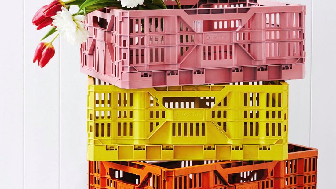 Pink, orange and yellow crates stacked on top of each other.