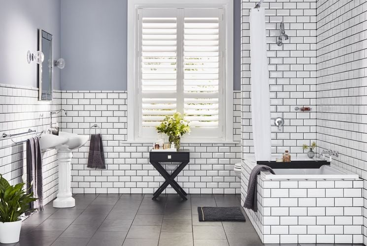 Bathroom with white tiled walls and bath and a sink