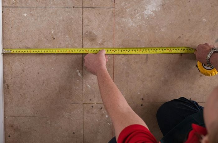 A person measuring the length of a kickboard.