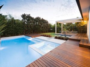 inground swimming pool with decking around it