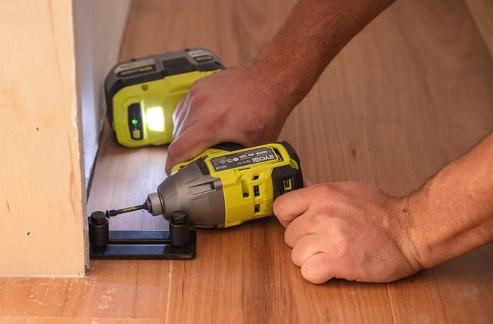 Team member installing door guides with a drill.