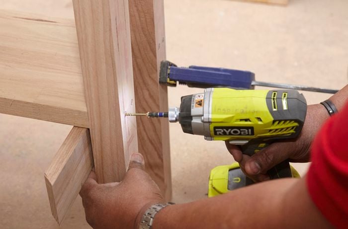 Person drilling shelf into table