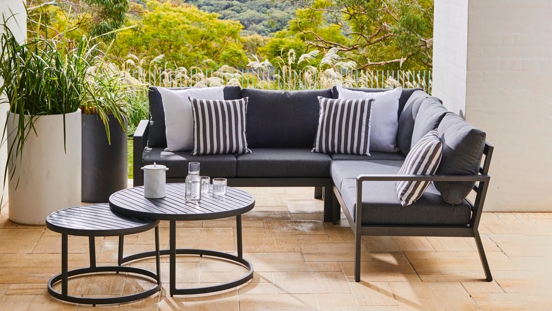Couch, plants and a coffee table in an outdoor area