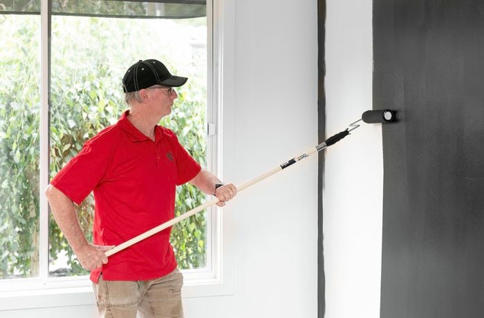 Painting the feature wall with a paint roller