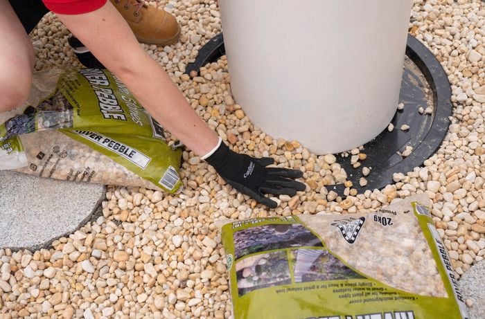A Bunnings Team Member putting pebbles on the base of a water feature