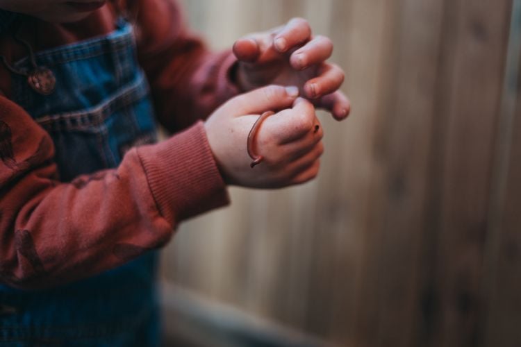 A child holding a worm
