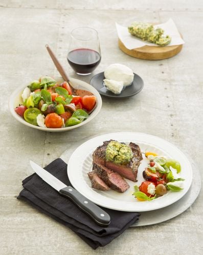 Plate of steak and vegetables next to a bowl of salad