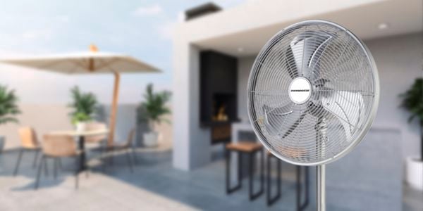 Fan in an outdoor setting with umbrella in shot