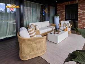 Outdoor area with a couch, chairs and table on a decking area.