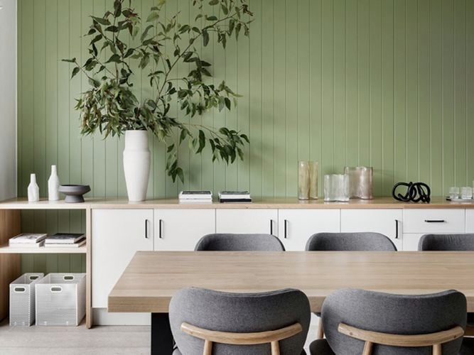 Timber dining table with green timber feature wall