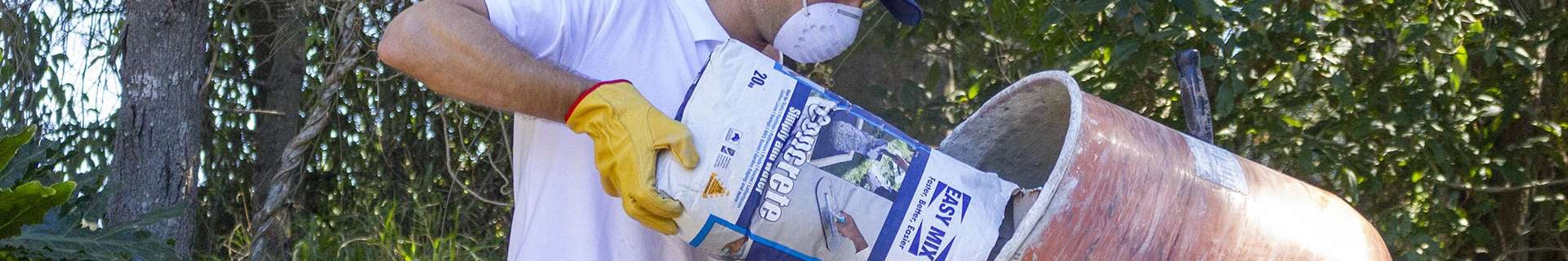 Man pouring concrete into concrete mixer