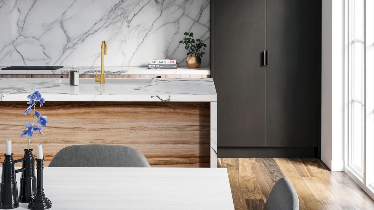 Close up of a full kitchen with model marble bench top, dining table and chairs