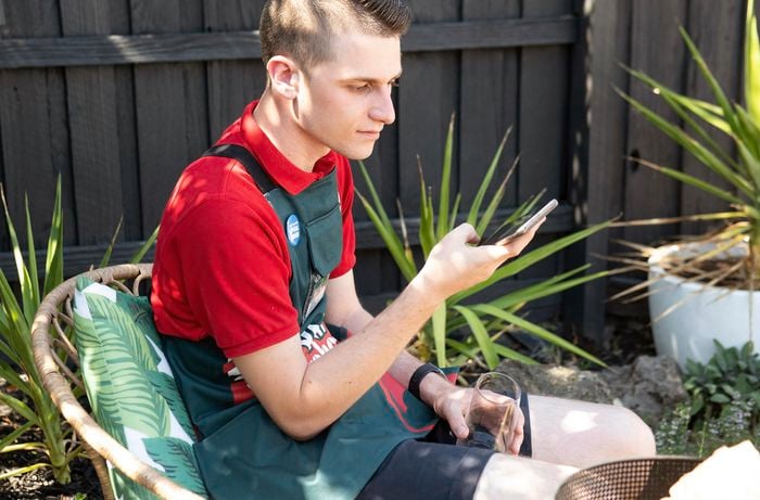 Person sitting down outside using their smart phone.