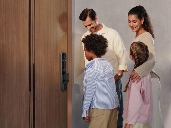 Family standing in front of a door equipped with a Philips Smart Lock