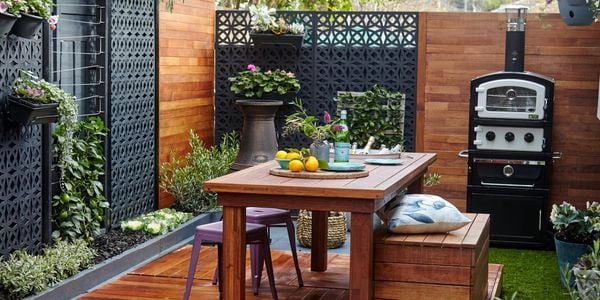 Outdoor entertaining area with outdoor setting and lots of plants.