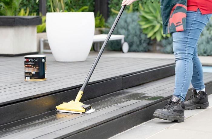 A pool deck being cleaned with a deck scrub