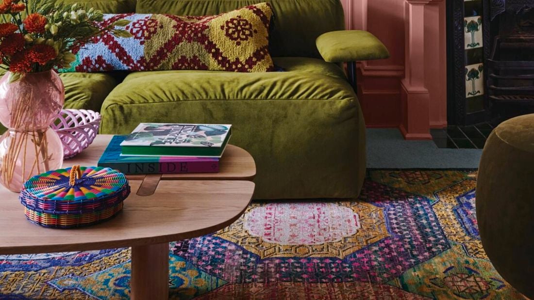 Pink painted room with green couch chairs 