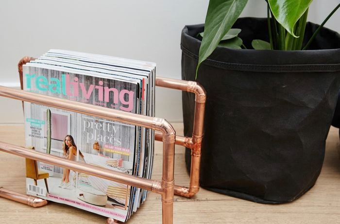 A magazine rack made from polished copper pipe