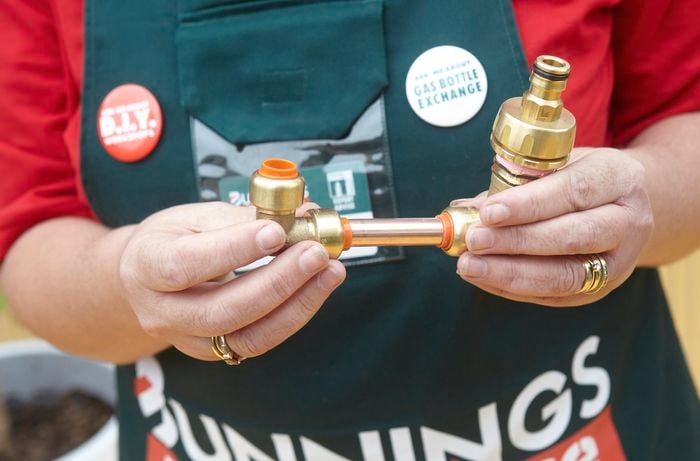 Person holding garden hose attachment.