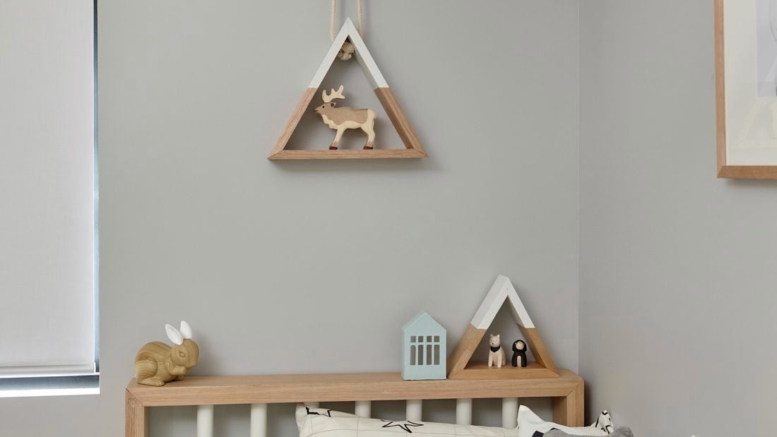 Wooden triangle shelves in a bedroom, one hanging from a rope