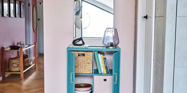 green cabinet sitting on timber floors, pink walls