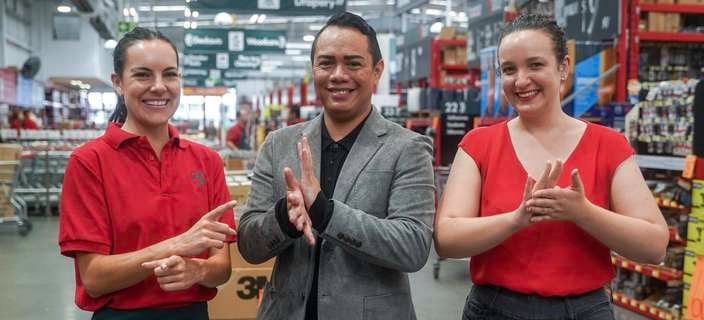 Team member and 2 Sign Language Experts standing in store signing
