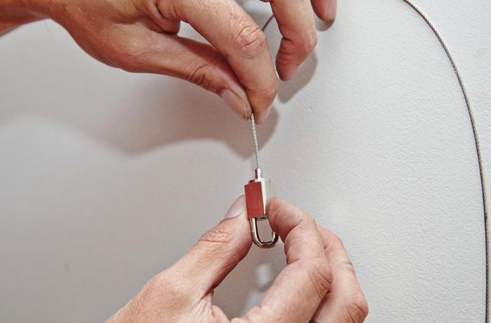 The length of a hanging wire being adjusted by feeding the wire through the hook