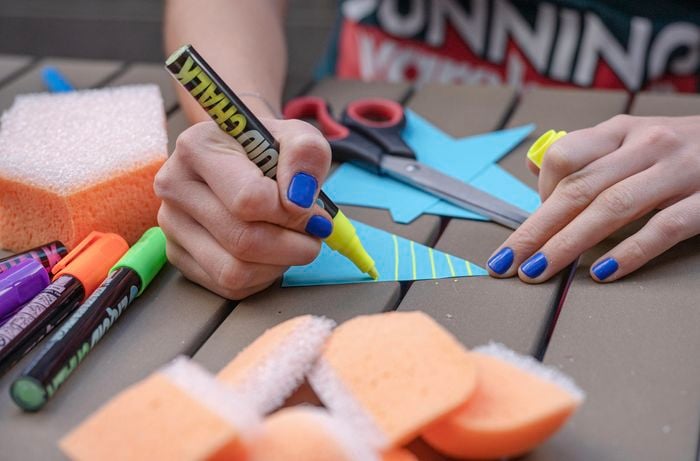 Woman applying colour to the cut out of sail.