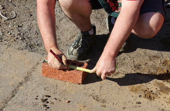 Person laying out bricks.