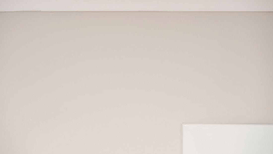 Freshly painted beige wall with a smooth, clean finish and no visible cracks or imperfections. 