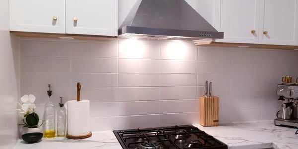 Kitchen with white cabinets, marble bench top and stainless steel appliances