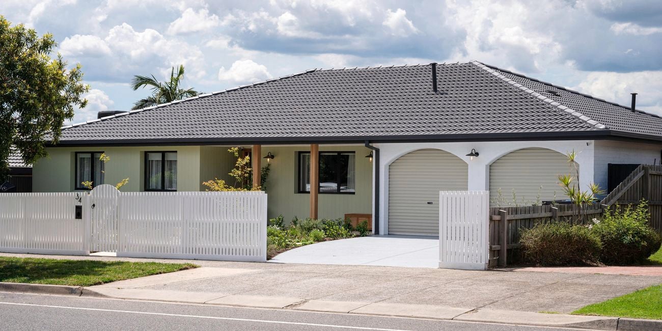 Front of house with a picket fence at the front of it