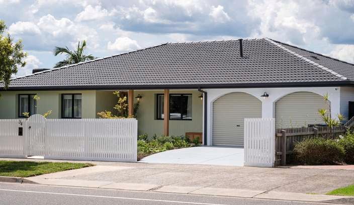 Front of house with a picket fence at the front of it