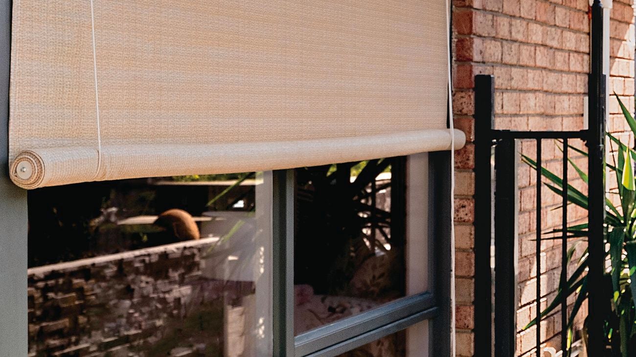House exterior with window and outdoor roll-up blind